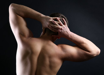 Handsome young muscular sportsman, on dark background