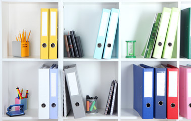White office shelves with folders and different stationery,