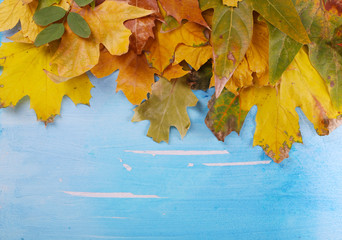Frame from autumn leaves on wooden table close-up