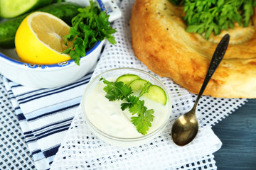 Cucumber yogurt in glass bowl and homemade bread,