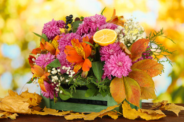 Flowers composition in crate with yellow leaves