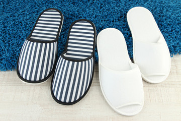 Striped and white slippers on floor background