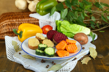 Fototapeta na wymiar Beautiful sliced vegetables, on plate, on wooden background