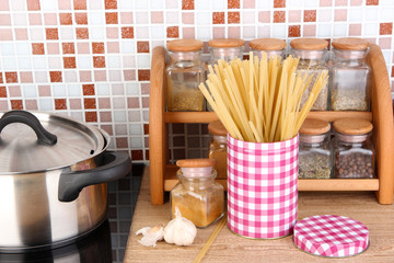 Pot on stove in kitchen on table on mosaic tiles background