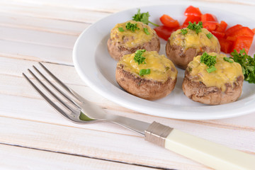 Stuffed mushrooms on plate on table on light background