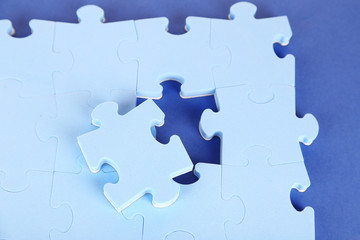Obraz premium Last piece of jigsaw puzzle, close-up, on blue background