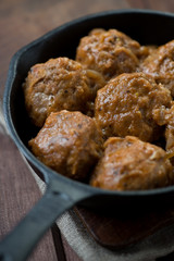 Close-up of meat balls in cast-iron pan, vertical shot