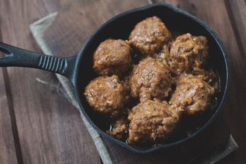 Meat balls with gravy in a frying pan, view from above