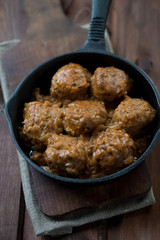 Meat balls with a sauce, rustic wooden background