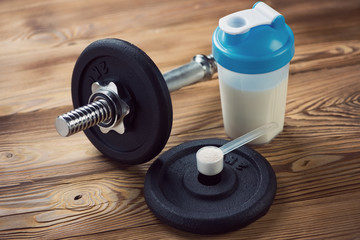 Bodybuilding: a dumbbell, a protein shake and a measuring scoop