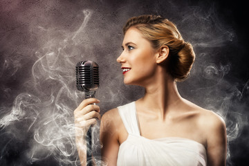 beautiful blonde woman singer with a microphone