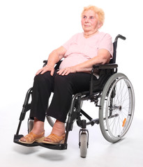 Elderly paraplegic woman sitting in a wheelchair on a white.