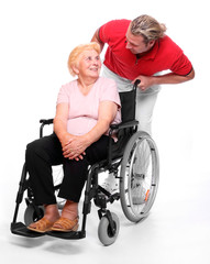 Elderly paraplegic woman in a wheelchair and her male nurse.