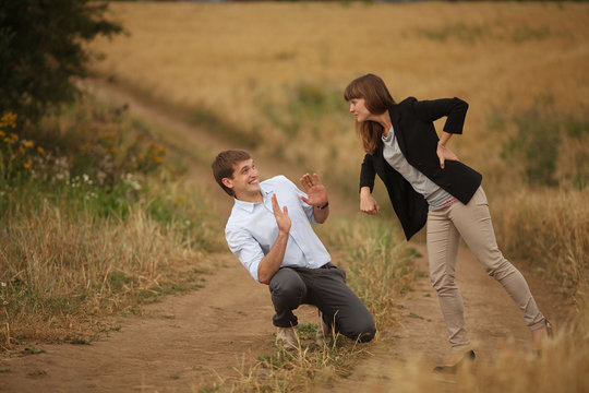 Young Man And Woman Walking In A Field Of Wheat