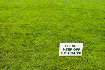 White Please keep off the grass sign on green grass.