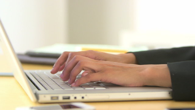 Close up of business woman's hands using laptop
