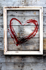 Wooden frame with red heart  on a grunge background