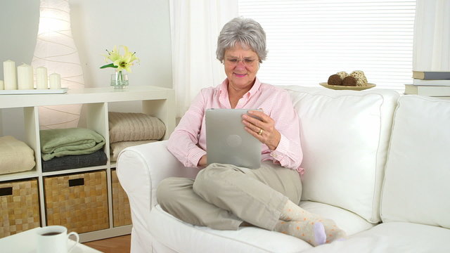 Smiling senior woman using tablet