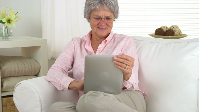 Happy senior woman using tablet