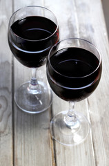 Two glasses of red white on the wooden background