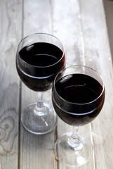 Two glasses of red white on the wooden background