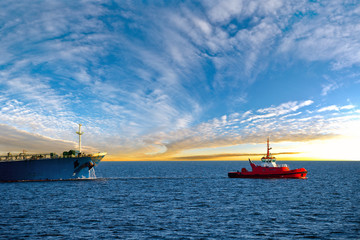Maritime Tugboat Pulling a Cargo Ship on a Sea. © Nightman1965