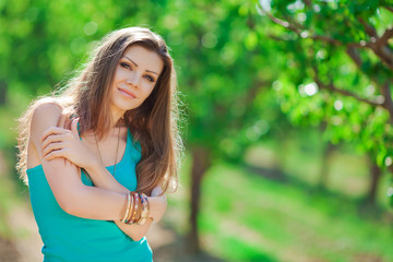 Naklejka premium portrait of a young woman on a background of green trees