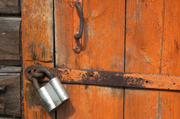 Old wooden door with padlock,  fragment