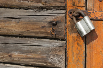 Old wooden door with padlock,  fragment