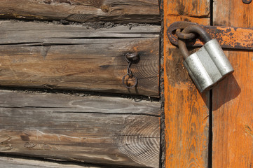 Old wooden door with padlock,  fragment
