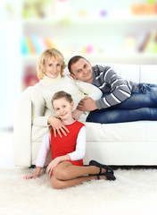 Family with girl sitting on white leather sofa