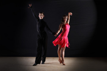 Latino dancers in ballroom against white background