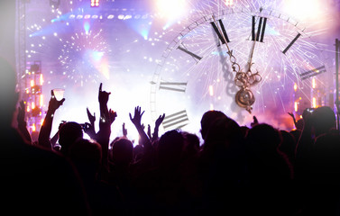 Clock close to midnight, fireworks and crowd waiting for New yea