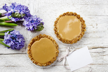 Toffee tarts on wooden table, violet hyacinth flower in the back