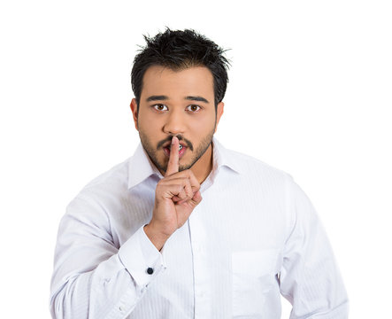 Man placing finger on lips as if to say, shh, be quiet