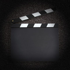 Blank movie production clapper board over dark background