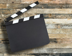 Blank movie production clapper board over wooden background