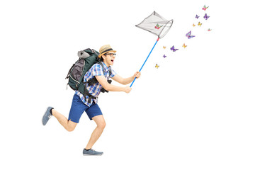 Full length portrait of a male tourist catching butterflies