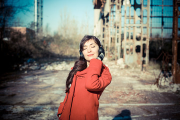 Fototapeta premium beautiful woman red coat listening music park