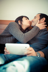 couple in love on the bed using tablet