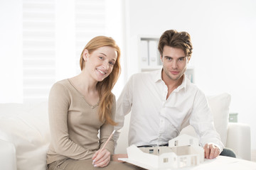 Fototapeta premium Couple studying a construction project with a model house