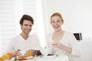 Obraz na płótnie Canvas young couple takes breakfast in kitchen