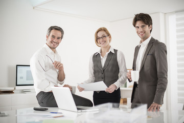 three colleagues speaks about business at office