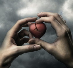 Broken red heart in hands