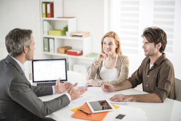 real-estate agent receives a young couple interested to invest i