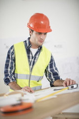 foreman in his office reviewing building plans