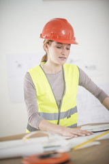 female foreman in his office is reviewing building plans