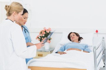 Fototapeta premium Doctor and surgeon visiting female patient