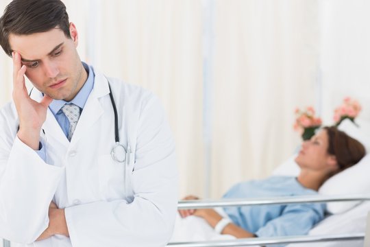 Worried Doctor With Patient In Hospital