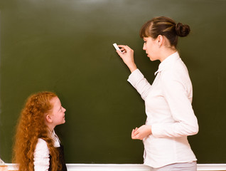 girl answers questions of teachers near a school board